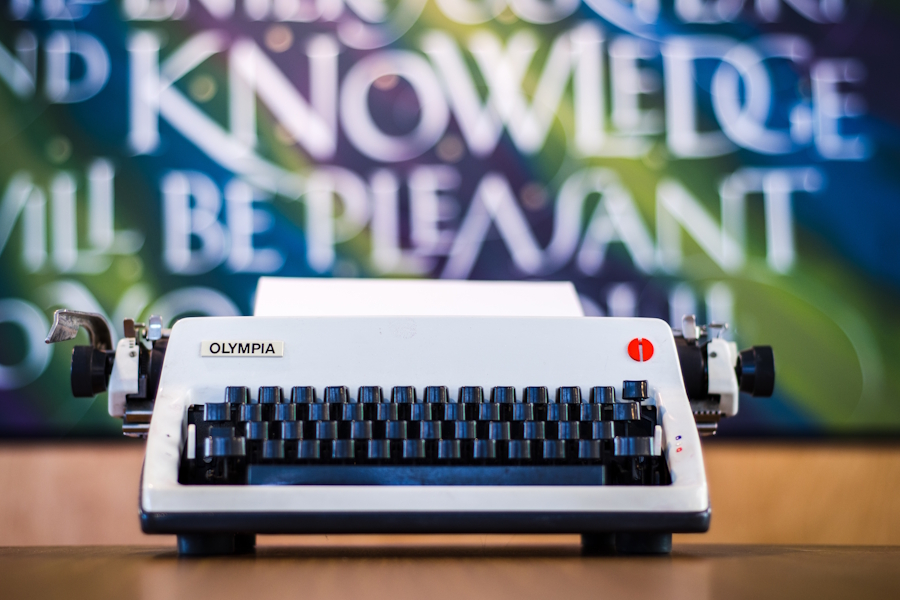 A typewriter owned by Dr. J.I. Packer sits in front of a colourful piece of calligraphic art