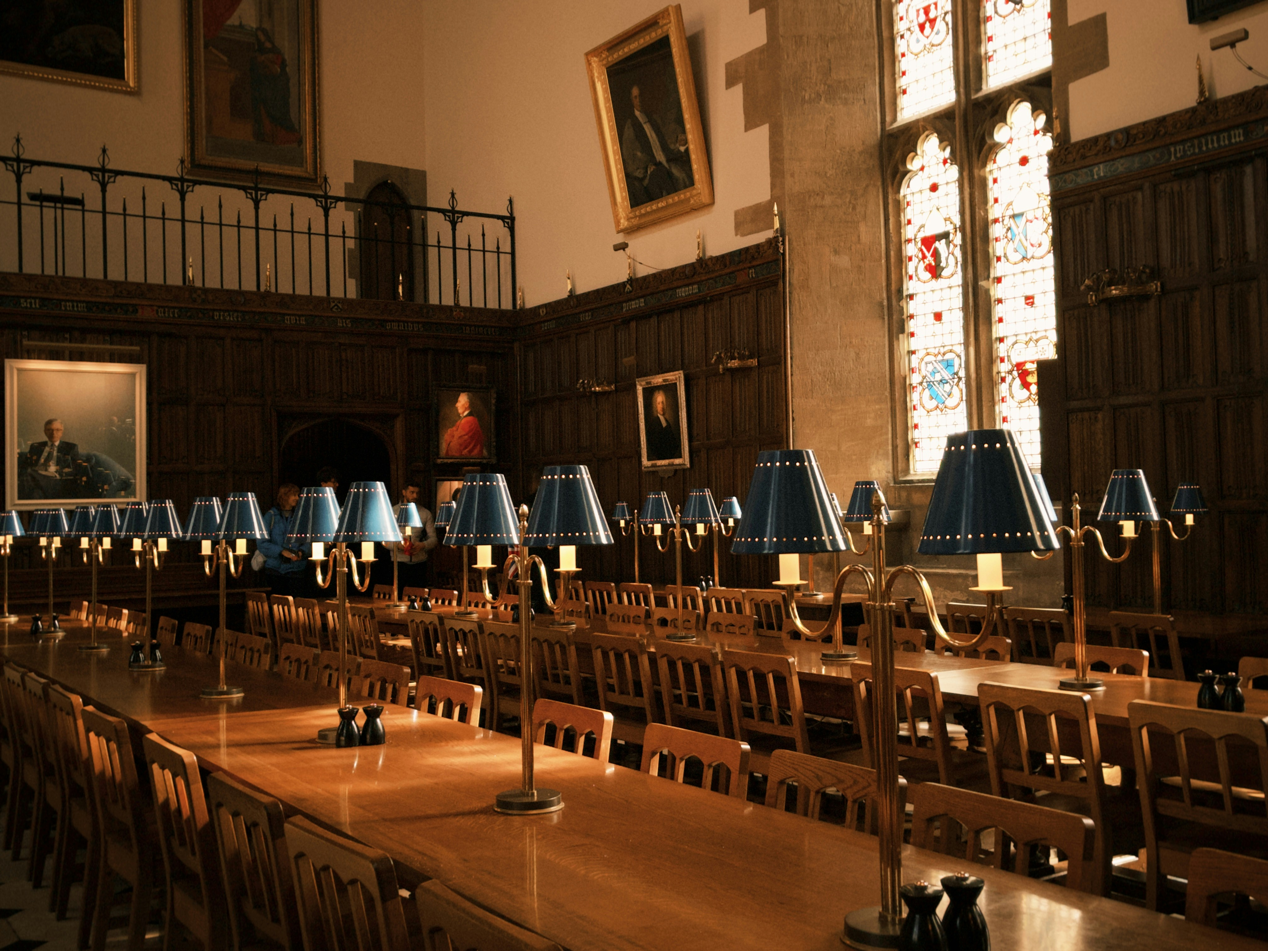A reading room at Oxford University bathed in natural light from a stained glass window