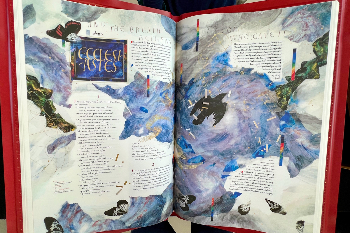 The opening pages of Ecclesiastes are illuminated by a black bird in flight amid a turbulent blue-grey sky.